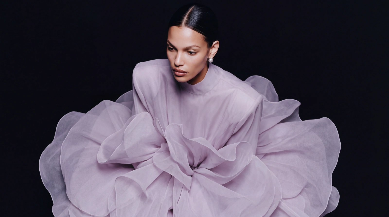 Model glancing aside in a voluminous lilac organza gown